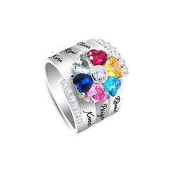 Silver personalized ring with multicolor heart-shaped birthstones arranged in a flower pattern, custom engraved with family member names on the band, accented with clear stones.