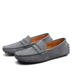 Pair of men's genuine suede penny loafers in gray with a slip-on design and driving shoe soles, ideal for casual and formal wear.