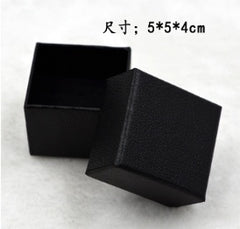 Black textured gift box with removable lid, suitable for packaging men's rings or other small jewelry items, displayed on a white background.