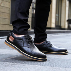 Black men's genuine leather lace-up Oxford shoes with a textured finish and contrasting sole, styled as comfortable business casual dress shoes.