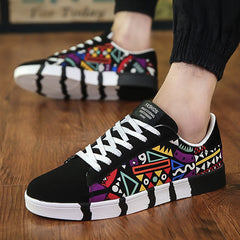 Men's low-top canvas sneakers featuring a vibrant multicolor geometric graffiti pattern with black accents and white laces, offering breathable comfort and urban style.