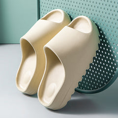 Pair of beige lightweight platform beach slides made from eco-friendly EVA foam with a thick sole, designed for comfort and casual wear.