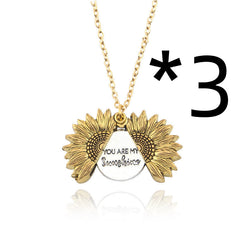 Gold-tone sunflower locket necklace with a hidden message inside that reads "You Are My Sunshine," reflecting a sentimental and heartfelt gift for loved ones.