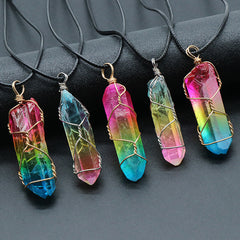 Five handcrafted crystal pendants with vibrant rainbow hues wrapped in wire, each hanging on a black cord, displayed against a dark background.