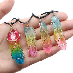 Hand holding four handcrafted crystal pendant necklaces featuring vibrant rainbow aura quartz wrapped in delicate wire on black cords, showcasing boho-inspired tree of life designs.