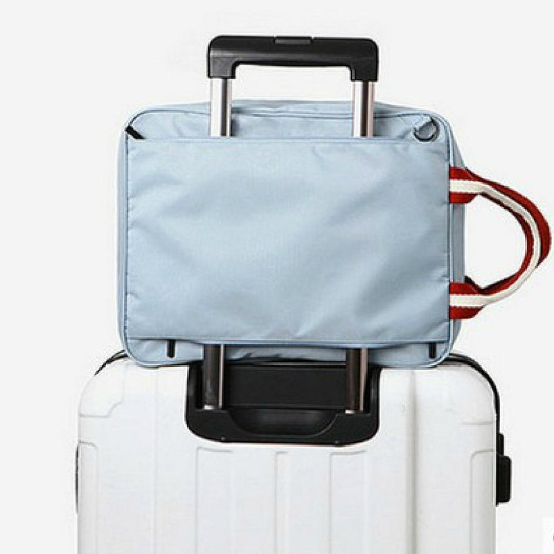 Close-up of a sleek black business bag secured to a suitcase handle using its integrated trolley sleeve for easy airport travel.
