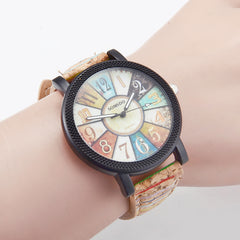 Vintage-inspired wristwatch with multicolor numbered dial and retro-style leather strap, worn on a wrist, blending casual and boho fashion elements.