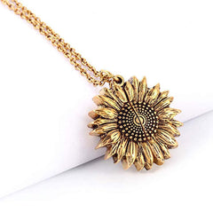 Gold sunflower-shaped locket necklace with detailed petals and center, hanging from a delicate chain, designed as a sentimental gift for women and men.
