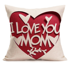 Decorative throw pillow with a cut-out heart design and the words "I love you mom" revealing a red background, ideal as a heartfelt Mother's Day gift.