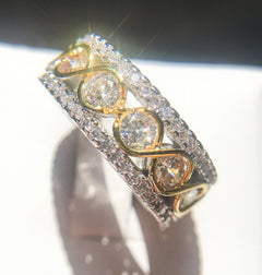 Close-up of a two-tone gold and silver infinity band ring featuring round cut cubic zirconia stones in a wide, multi-row stackable design, ideal as an anniversary gift.