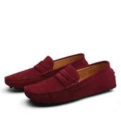 Pair of men's genuine suede penny loafers in deep red, featuring classic slip-on design with detailed stitching, ideal for casual and formal wear.