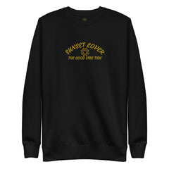 Black fleece sweatshirt with yellow "Sunset Lover The Good Vibe Tide" text and sun graphic printed on the front, featuring a classic crewneck and long sleeves.