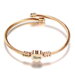 Rose gold textured cable bracelet with a heart-shaped charm engraved with "Mom," a delicate personalized gift ideal for Mother's Day or heartfelt occasions.