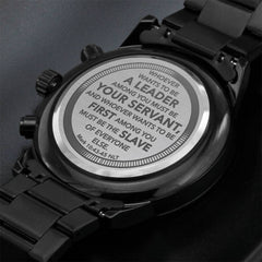 Close-up of the back of a black men's chronograph watch engraved with the scripture Mark 10:43-45, emphasizing servant leadership and faith.