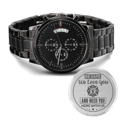 Engraved charcoal black men's chronograph watch with a linked metal band, featuring a heartfelt message for a firefighter husband on a silver plaque beside the watch.