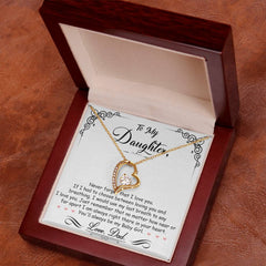 Gold heart-shaped necklace with a sparkling cubic zirconia pendant displayed in a wooden gift box, accompanied by a heartfelt message from a father to his daughter.
