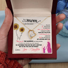 Heart-shaped gold necklace with a sparkling crystal pendant displayed in a gift box featuring a heartfelt message from daughter to mom with sunflowers and silhouettes.