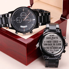 Charcoal black men's chronograph watch with engraved romantic message on the back, displayed open next to a polished wooden gift box.