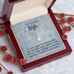 Elegant silver necklace with a sparkling cushion cut cubic zirconia pendant, displayed in an open gift box with a heartfelt message for a wife, surrounded by decorative red berries.