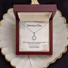 Unbiological Sister Eternal Hope necklace by ShineOn Fulfillment in a burgundy jewelry box with a silver halo pendant