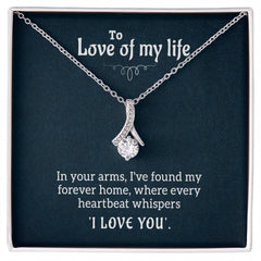 Silver necklace with a sparkling ribbon-shaped pendant displayed on a dark background featuring a romantic message expressing love and devotion.