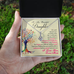 Hand holding an open gift box with a silver necklace and an inspirational message card titled To My Beautiful Daughter - Alluring Beauty Necklace, featuring a colorful tree illustration and a heartfelt note from a mother.