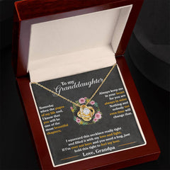 Gold love knot necklace with cubic zirconia pendant displayed in an elegant wooden gift box, accompanied by a heartfelt message from a grandfather to his granddaughter.