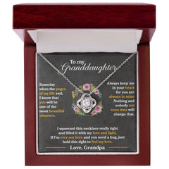 Silver love knot necklace with cubic zirconia crystals displayed in an elegant wooden gift box, accompanied by a sentimental message to a granddaughter.