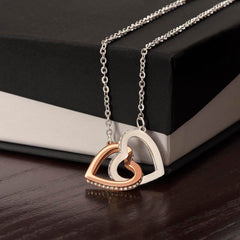 Interlocking Hearts Necklace with two-tone rose gold and silver heart pendants, crystal-accented edge, on silver chain.