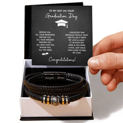 Handcrafted black braided leather bracelet with metallic accents, presented in a gift box alongside a heartfelt graduation message card for a son.