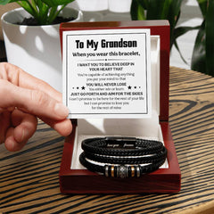 Engraved men's black leather bracelet with motivational message for grandson, displayed in an open wooden gift box with a card expressing love and encouragement.