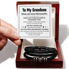 Black engraved men's leather bracelet with decorative metal accents presented in a wooden gift box alongside a heartfelt message card from a grandparent to their grandson.