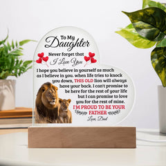 Heart-shaped acrylic plaque with an inspiring message from a father to his daughter, featuring images of a lion and lion cub, displayed on a wooden base in a bright room.