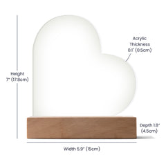 Clear acrylic heart plaque with smooth edges, displayed on a rectangular wooden base, featuring dimensions and thickness details for home décor or personalized gift use.