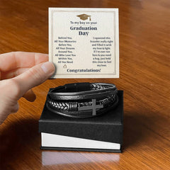 Handcrafted men's leather bracelet with a stainless steel cross, presented in a gift box alongside a heartfelt graduation message card.
