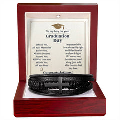 Black braided leather bracelet with a stainless steel cross displayed in a wooden gift box, accompanied by a heartfelt graduation message card for a son.
