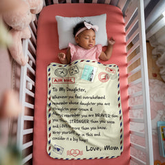 Sleeping baby girl in a crib covered with a soft sherpa fleece blanket featuring an encouraging, heartfelt message from mom to daughter, designed like an airmail letter.