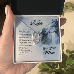Close-up of a silver heart-shaped pendant necklace with a sparkling stone inside, displayed in a gift box with a heartfelt message to a daughter, featuring the text "Old Wolf - Forever Love Necklace.