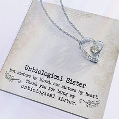 Necklace: Unbiological Sister Forever Love pendant in silver with an open-heart design and crystal accents