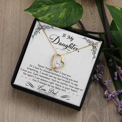 Gold heart-shaped necklace with a sparkling crystal centerpiece displayed on a sentimental card with a heartfelt message from a father to his daughter.