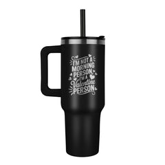 Black laser engraved stainless steel tumbler with handle and straw, featuring humorous morning and Valentine’s Day message, designed for keeping beverages hot or cold.