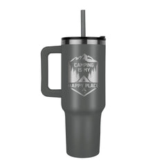 Matte gray stainless steel tumbler with handle and lid, laser-engraved with a camping-themed design and the phrase "Camping is my happy place," featuring mountains and trees.