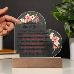 Heart-shaped clear acrylic plaque with pink floral accents and a sentimental message from parents to daughter, illuminated by LED light, displayed on a wooden base.