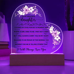 Heart-shaped personalized LED acrylic plaque with a heartfelt message, illuminated in purple light and decorated with floral designs, displayed on a wooden base.