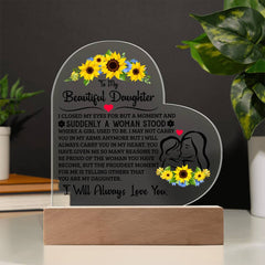 Heart-shaped acrylic plaque with a loving message to a daughter, decorated with sunflowers and a silhouette of a mother and daughter, displayed on a wooden base.