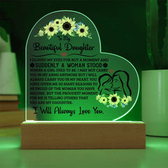 Heart-shaped acrylic plaque with a heartfelt message for a daughter, illuminated on a wooden base, featuring sunflower accents and a mother and daughter illustration.
