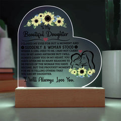 Heart-shaped acrylic plaque with floral designs and a heartfelt message from a parent to their daughter, illuminated on a wooden base, ideal as a sentimental gift.