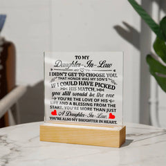 Heartfelt acrylic plaque with light-up wooden base, featuring a loving message for a daughter-in-law expressing gratitude and appreciation, displayed on a marble surface.
