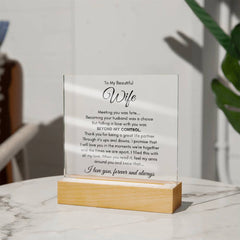 Clear acrylic plaque with a heartfelt message to a wife, displayed on a wooden base, placed on a marble surface with soft natural lighting and a blurred background.