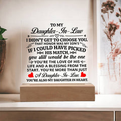 Clear acrylic plaque with a heartfelt message for a daughter-in-law, illuminated by a light-up wooden base, displayed on a tabletop near dried floral decor.